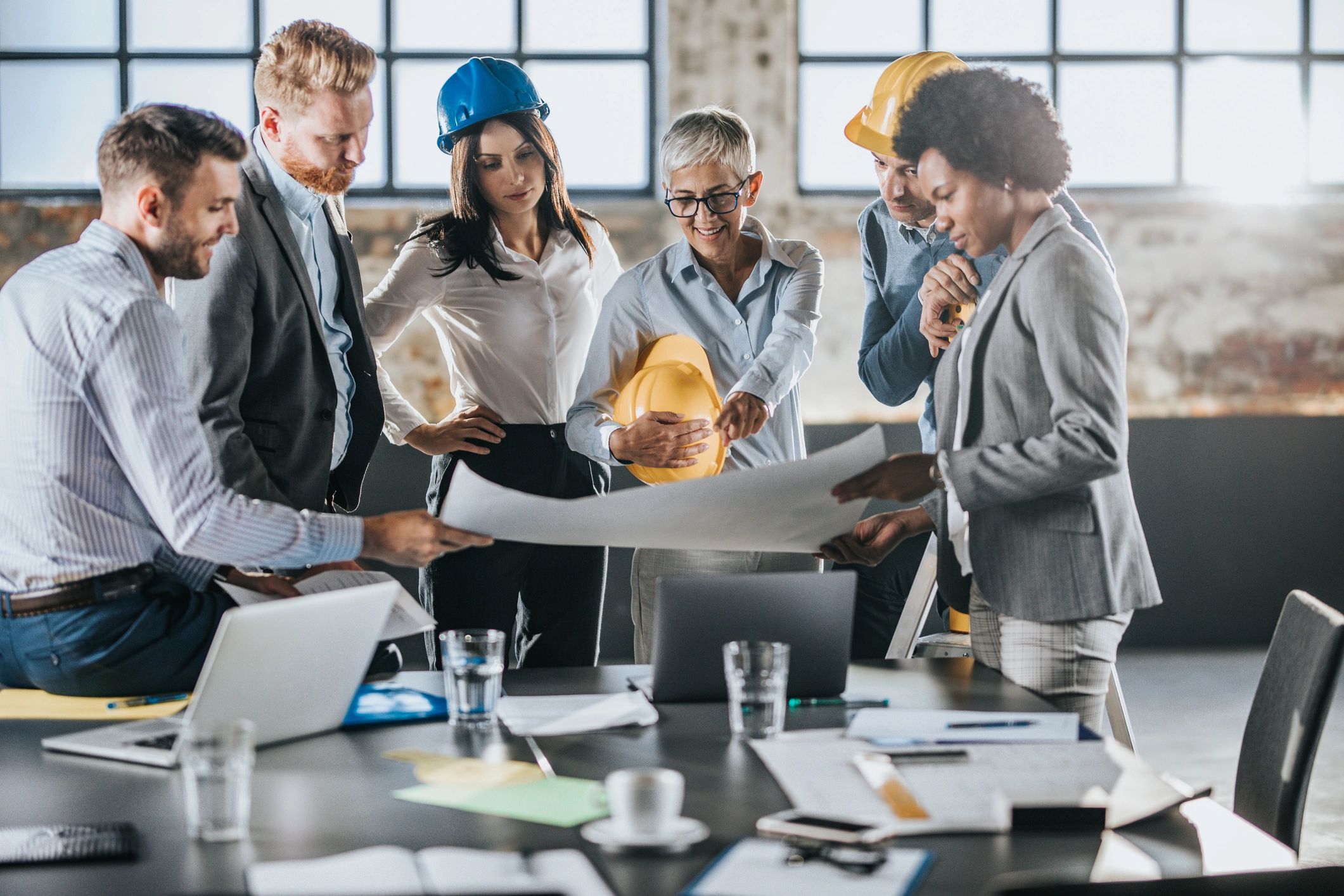 Project team reviewing construction plans and collaborating on decisions.