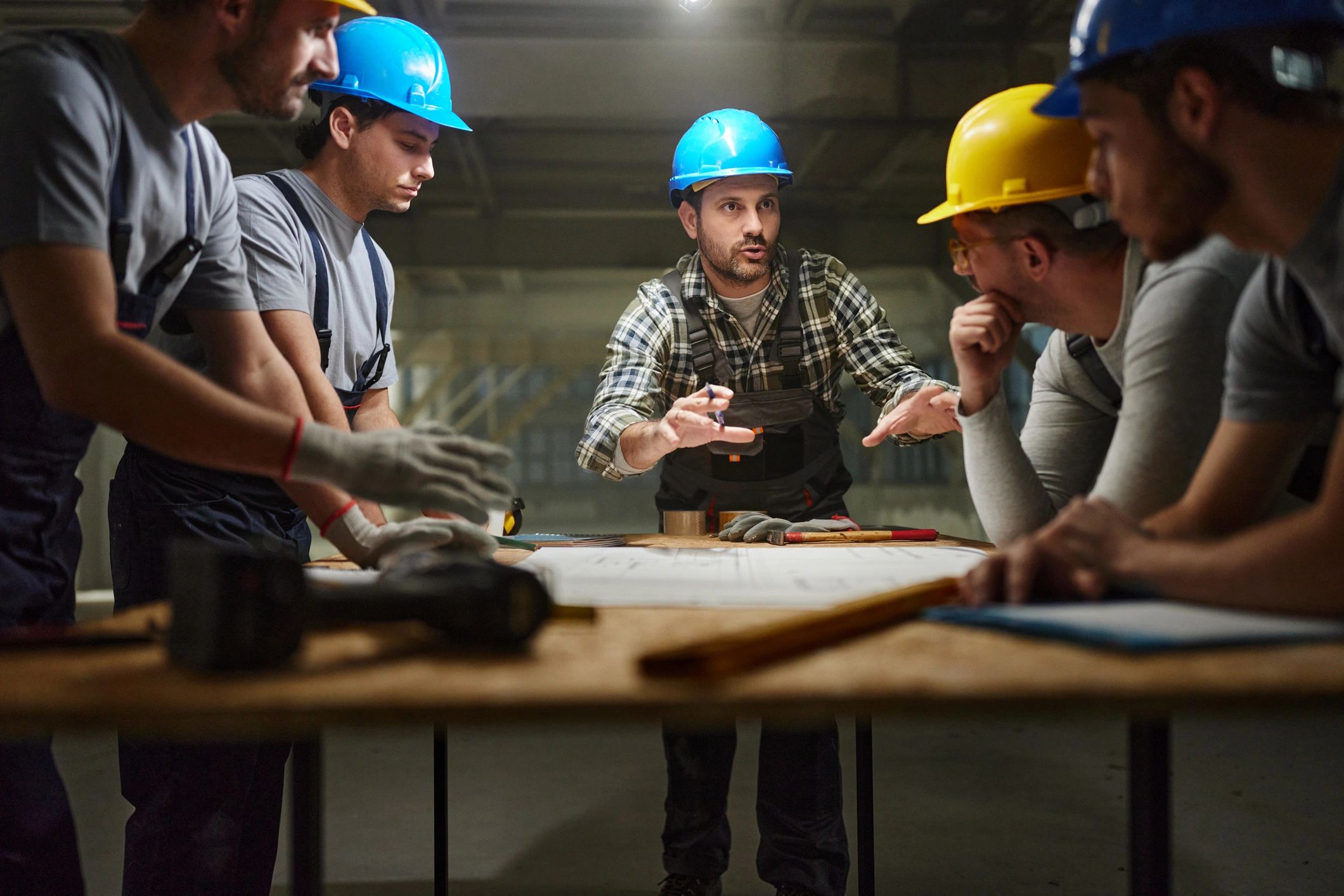 Construction worker discussing plans with colleagues on site
